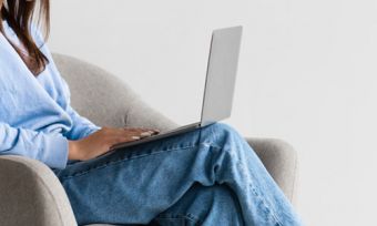 Woman on armchair looking at laptop