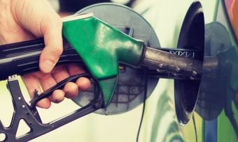 Hand holding fuel pump to car and filling it up.