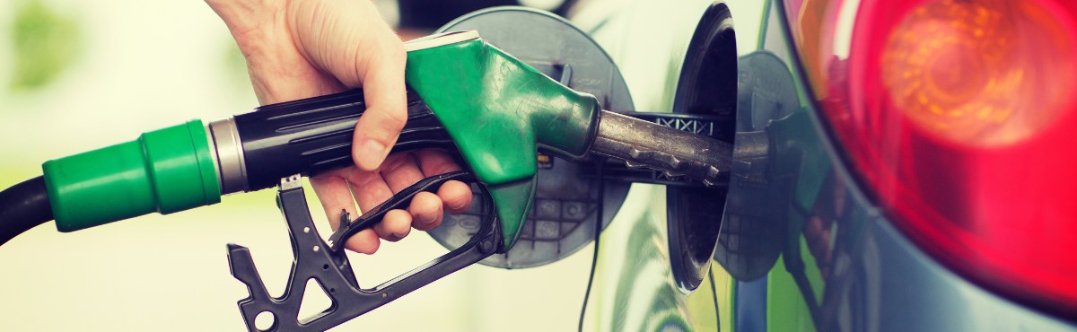 Hand holding fuel pump to car and filling it up.