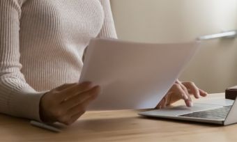 Woman on computer comparing bills.
