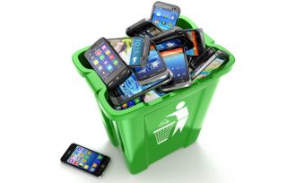 Smartphones piled in a green recycling bin