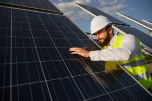 man inspecting solar panels