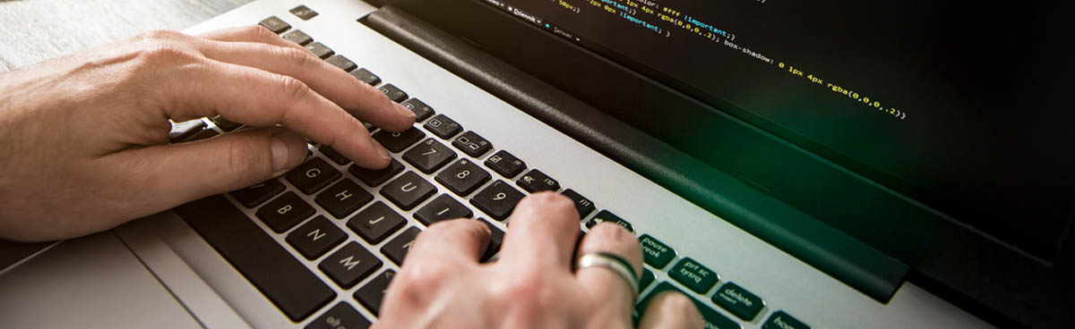 Close up of hands on keyboard typing code