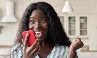 Woman staring at phone, excited.