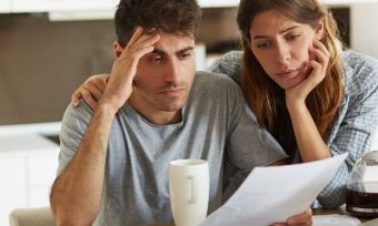 Couple looking at bills while stressed.