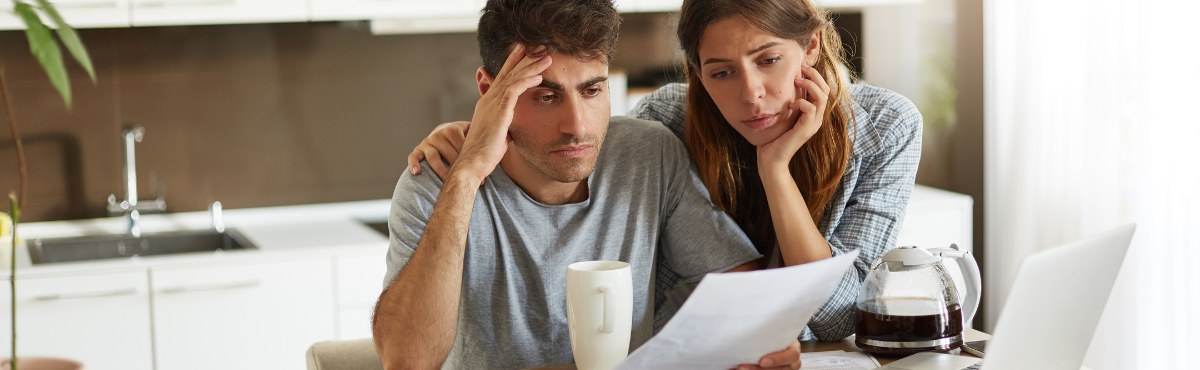 Couple looking at bills while stressed.