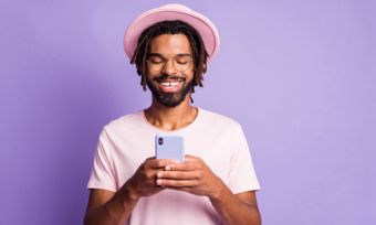 Man looking at smartphone against purple background