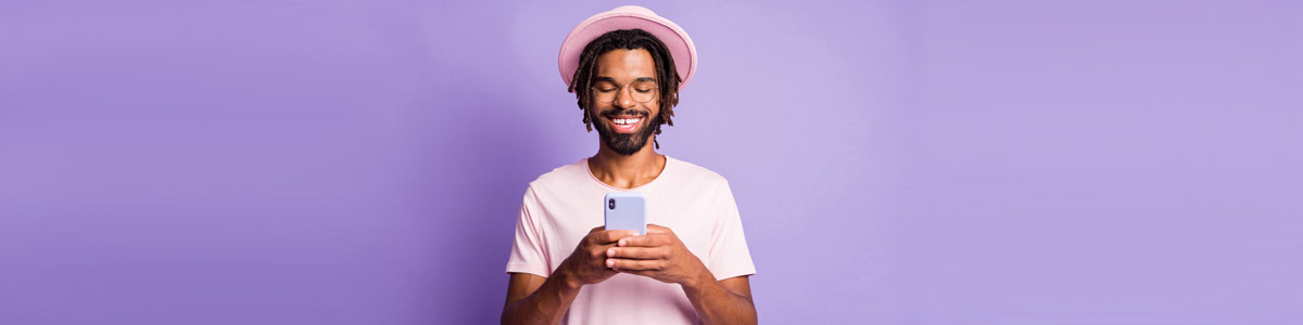 Man looking at smartphone against purple background