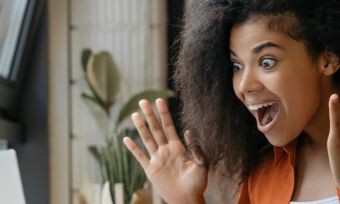 Woman looking at computer, very excited.