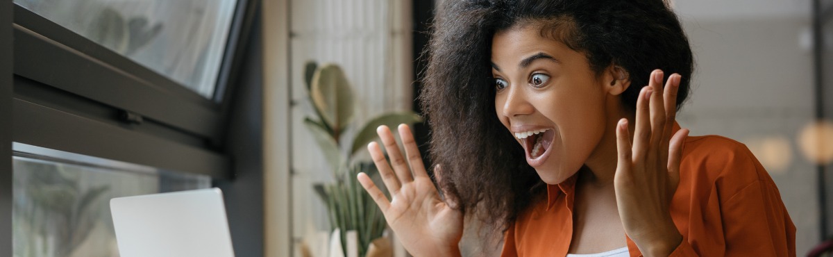 Woman looking at computer, very excited.
