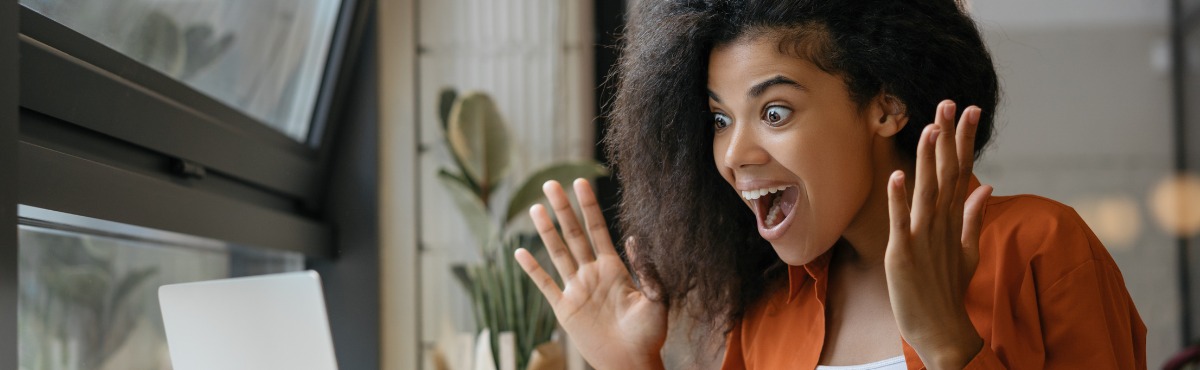 Woman looking at computer, very excited.