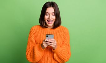 Woman looking at phone against green background