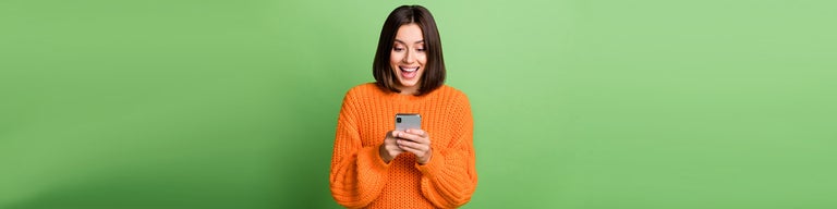 Woman looking at phone against green background