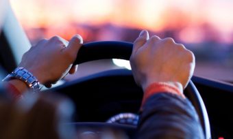 Over the shoulder view of man driving vehicle.