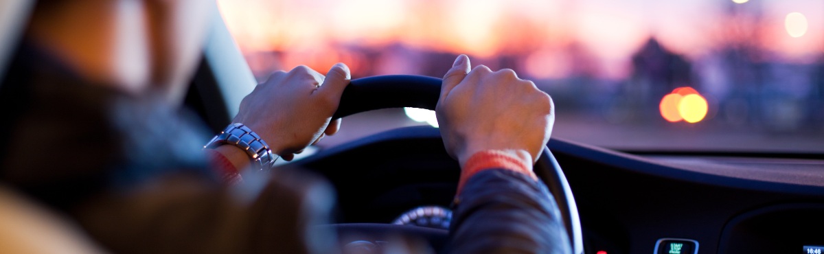 Over the shoulder view of man driving vehicle.