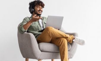 Smiling man using laptop with headphones