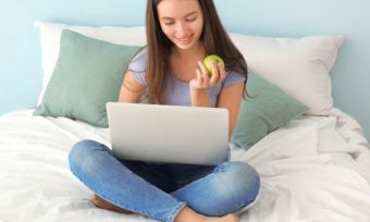 Teen girl using laptop in bedroom