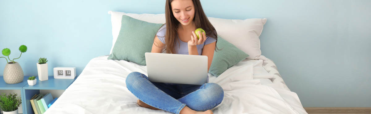 Teen girl using laptop in bedroom