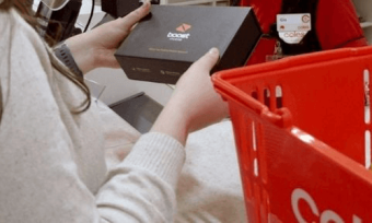 Woman holding Boost mobile box in Coles