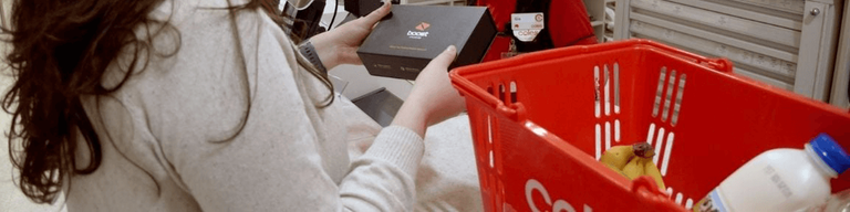 Woman holding Boost mobile box in Coles
