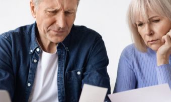 Older couple lookin at bills together, confused.