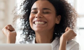 Woman happy at computer.