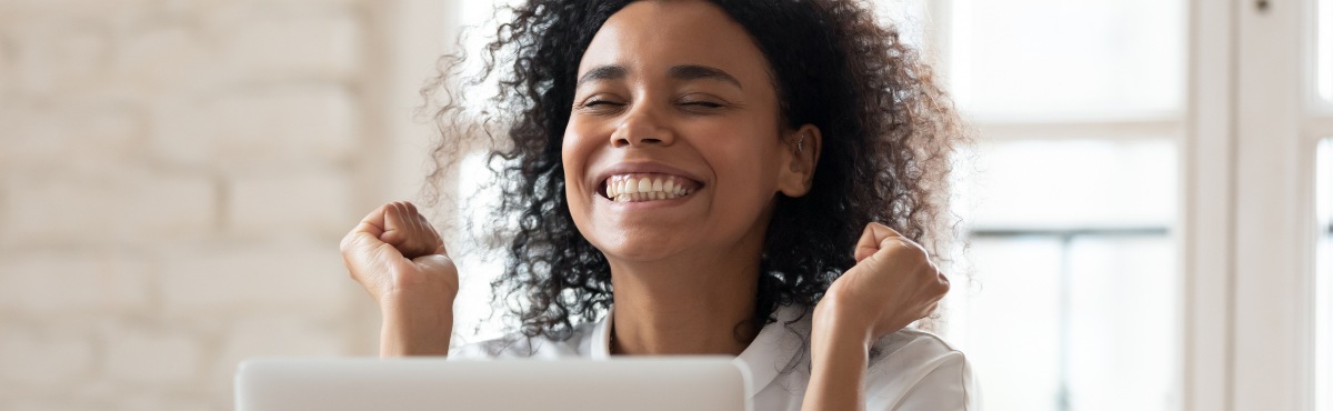Woman happy at computer.
