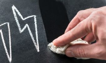 Lightning bolts drawn on a blackboard being rubbed out with eraser.