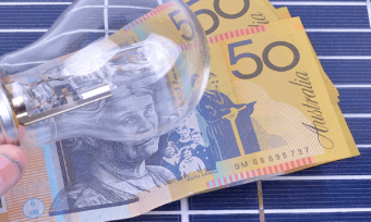 Solar panels with Australian dollars and a light bulb on top of it.