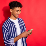 Man looking at phone against red background