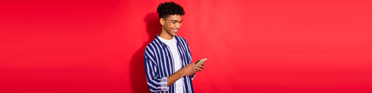 Man looking at phone against red background