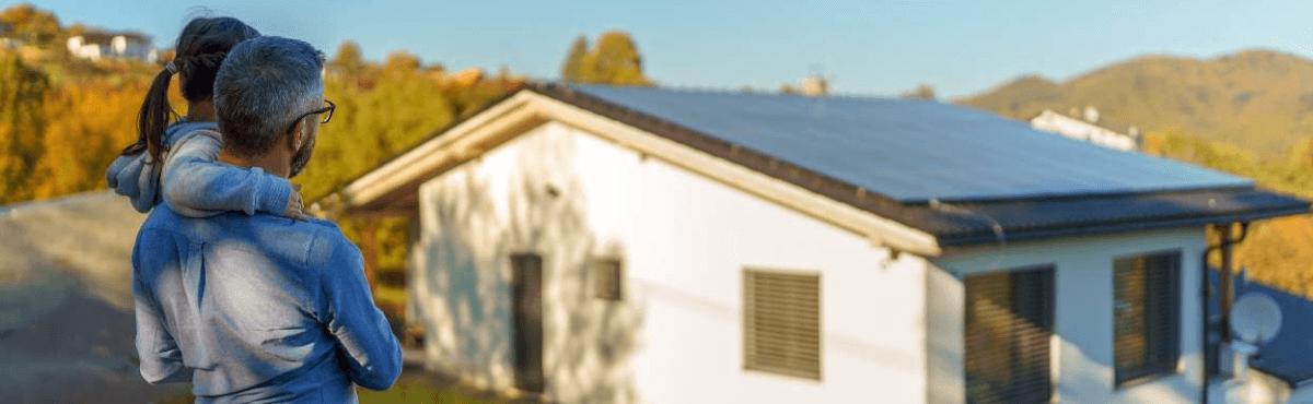 Man and his daughter looking at rooftop solar on a house.