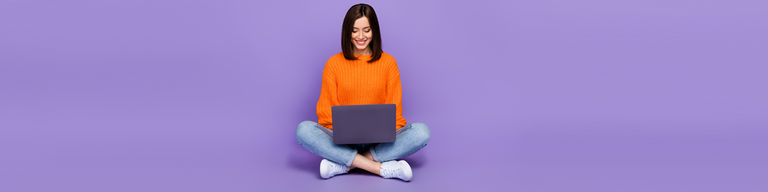 Woman looking at laptop against purple background