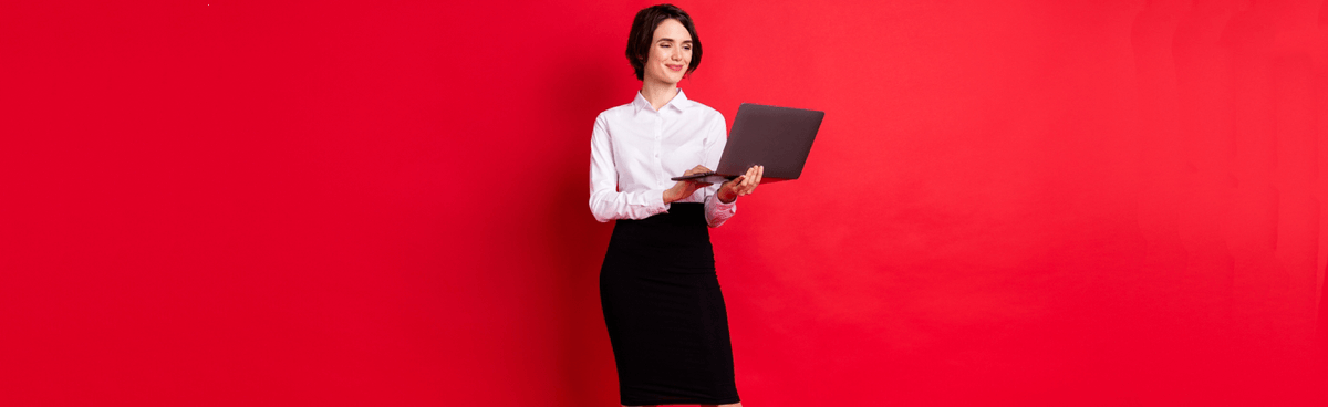 Smiling woman using laptop with red background