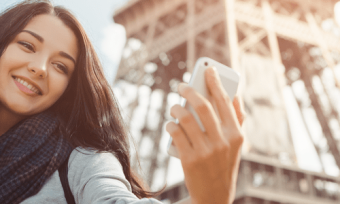 Woman taking selfie infront of Eiffel tower