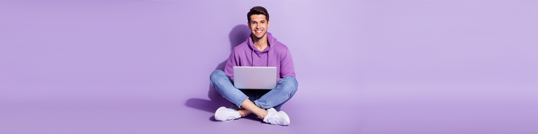 Man with laptop against purple background