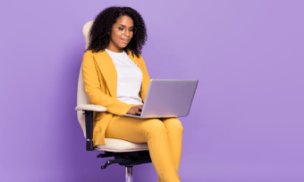 Woman looking at laptop against purple background