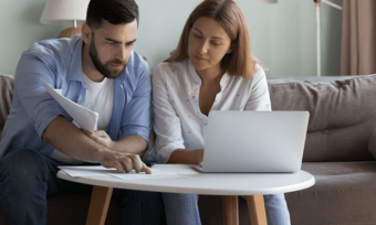 Anxious couple paying bills and using laptop