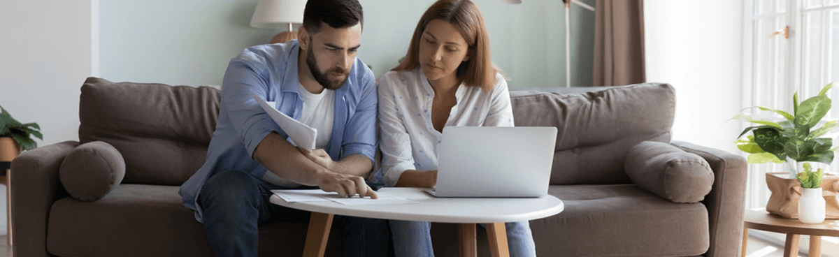 Anxious couple paying bills and using laptop