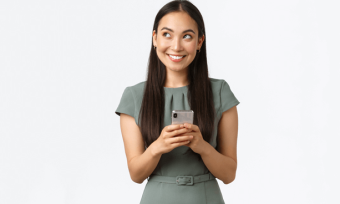 Smiling woman using mobile phone, wearing green dress