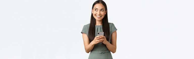 Smiling woman using mobile phone, wearing green dress