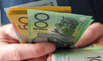 Man holding handful of Australian cash notes.