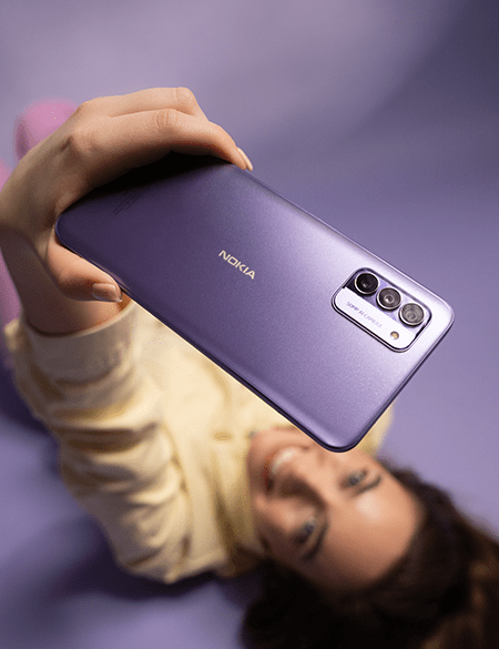 Woman holding Nokia G42 phone in purple