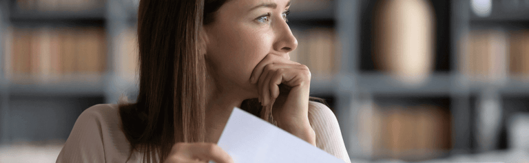 Woman looking anxious at her energy bill