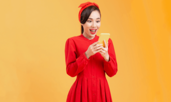 Young surprised woman in red looking at phone