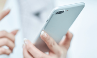 Woman's hands using a silver smartphone