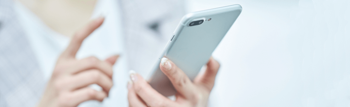 Woman's hands using a silver smartphone