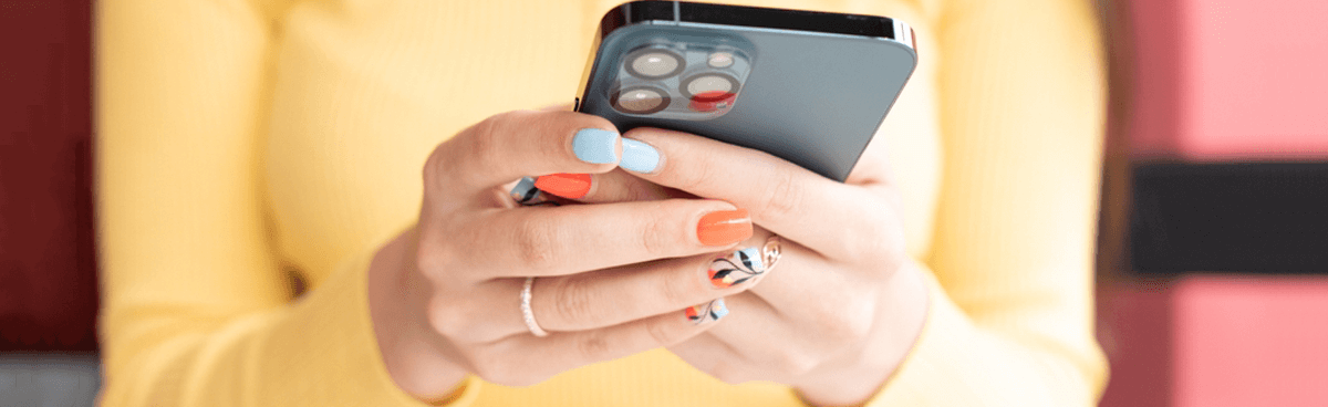 Close-up of woman's hands holding grey iPhone