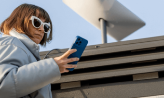 Woman using phone next to Starlink satellite