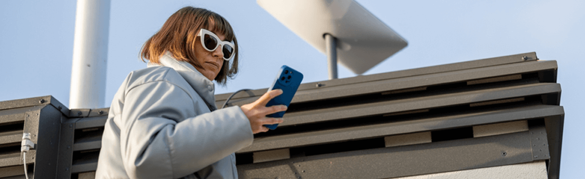 Woman using phone next to Starlink satellite